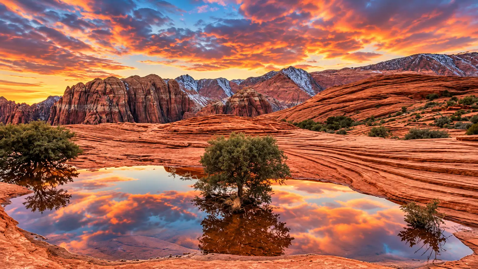 Sunset clouds reflected in pools among red sandstone formations